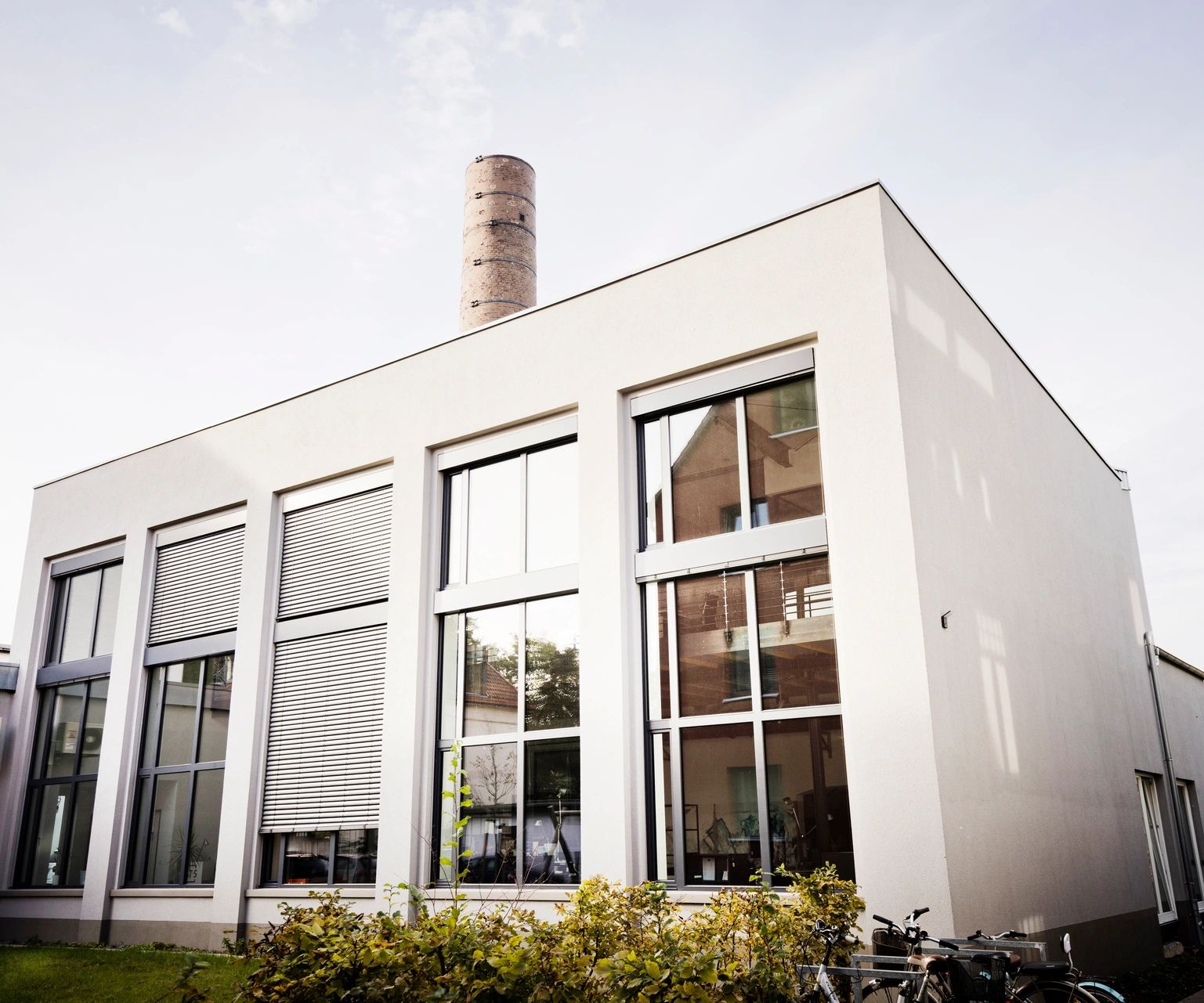 Außenansicht eines modernen Flachbaus mit großen Fensterflächen